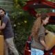 couple getting carton boxes out of red car while relocating in new home