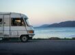rv vehicle on lakeshore at dusk