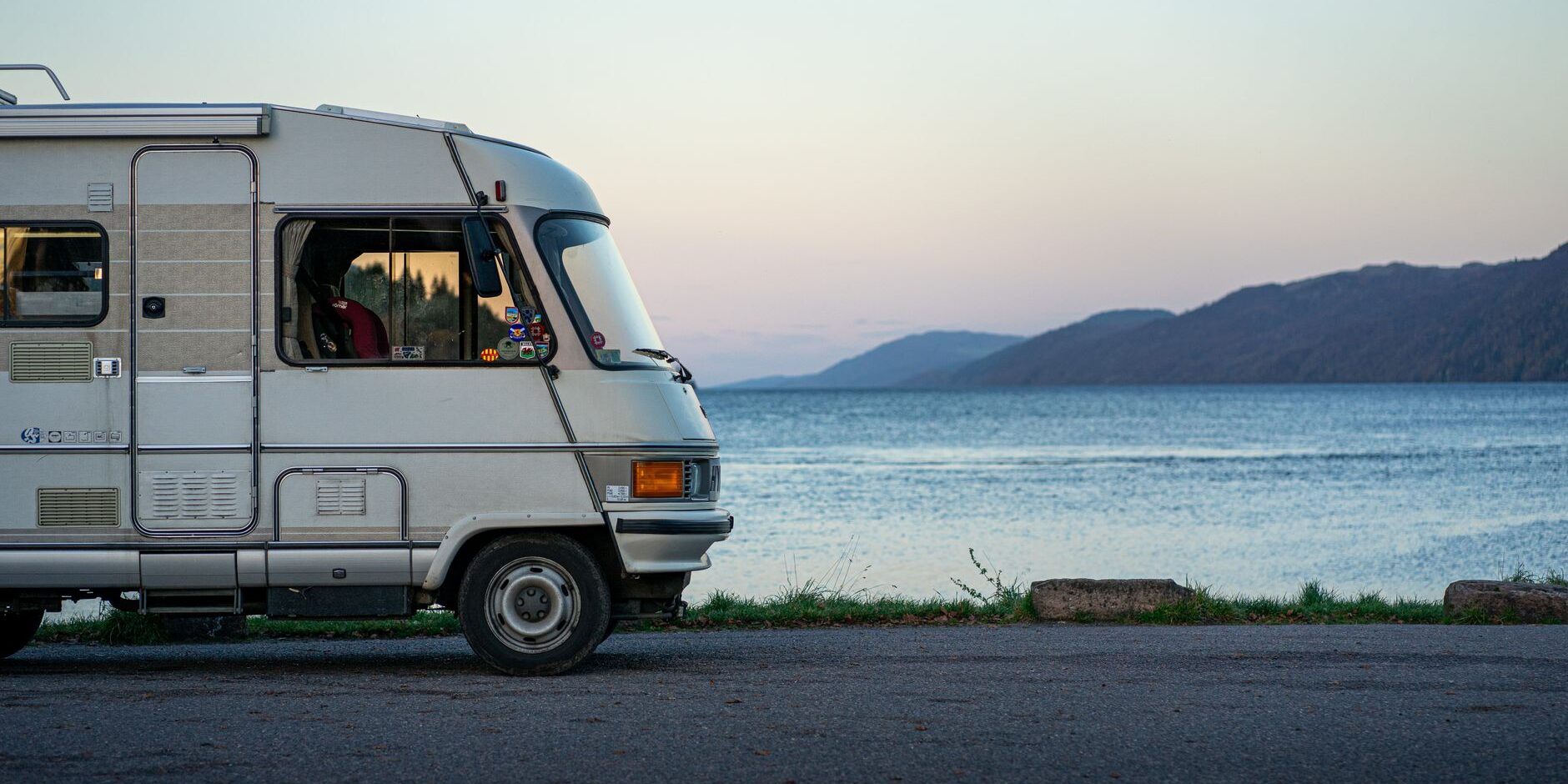 rv vehicle on lakeshore at dusk