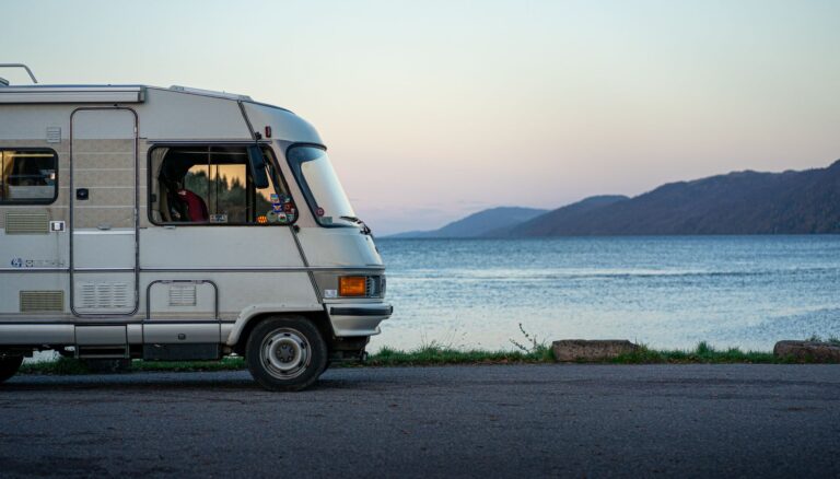 rv vehicle on lakeshore at dusk