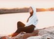 woman in gray hoodie sitting on rock