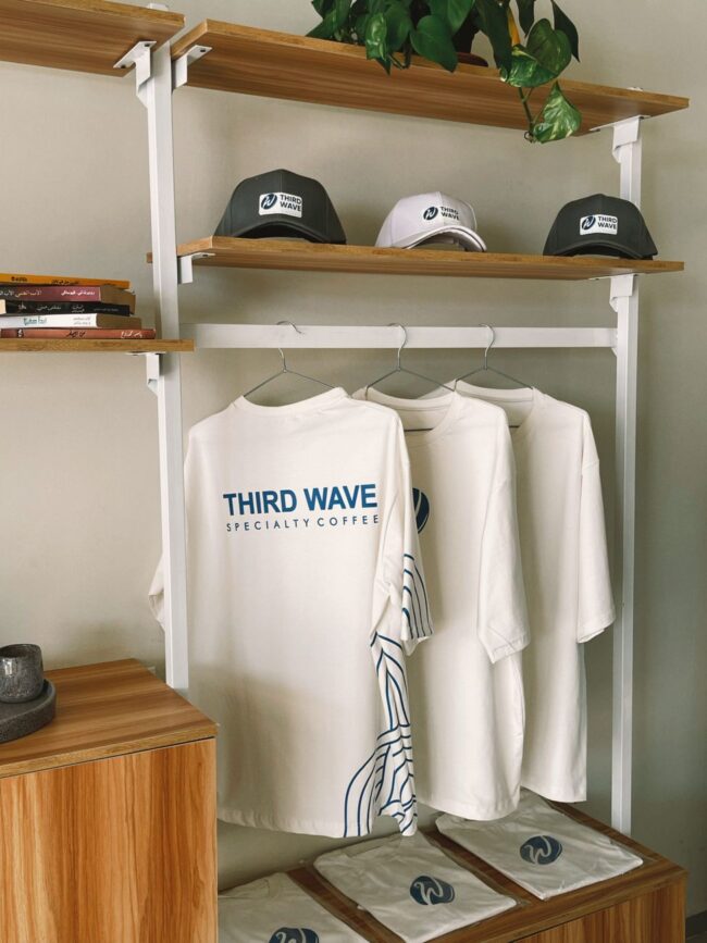 cafe merchandise display with t shirts and caps