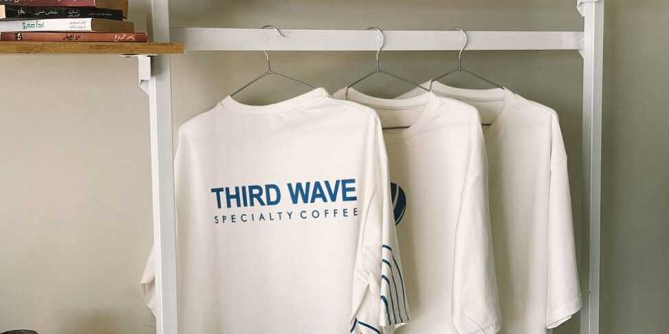 cafe merchandise display with t shirts and caps